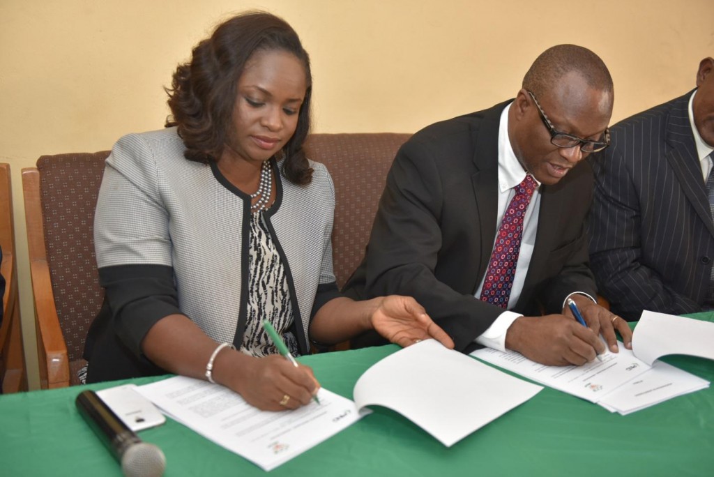 PIND Program Director Dr. Dara Akala and Ondo State WECA Chairperson Bolanle Olafunmiloye sign the paperwork